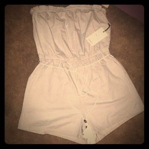 Light blue denim romper with white tassel belt